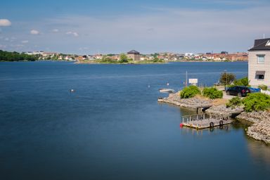 A small dock, the ocean, and houses on the background